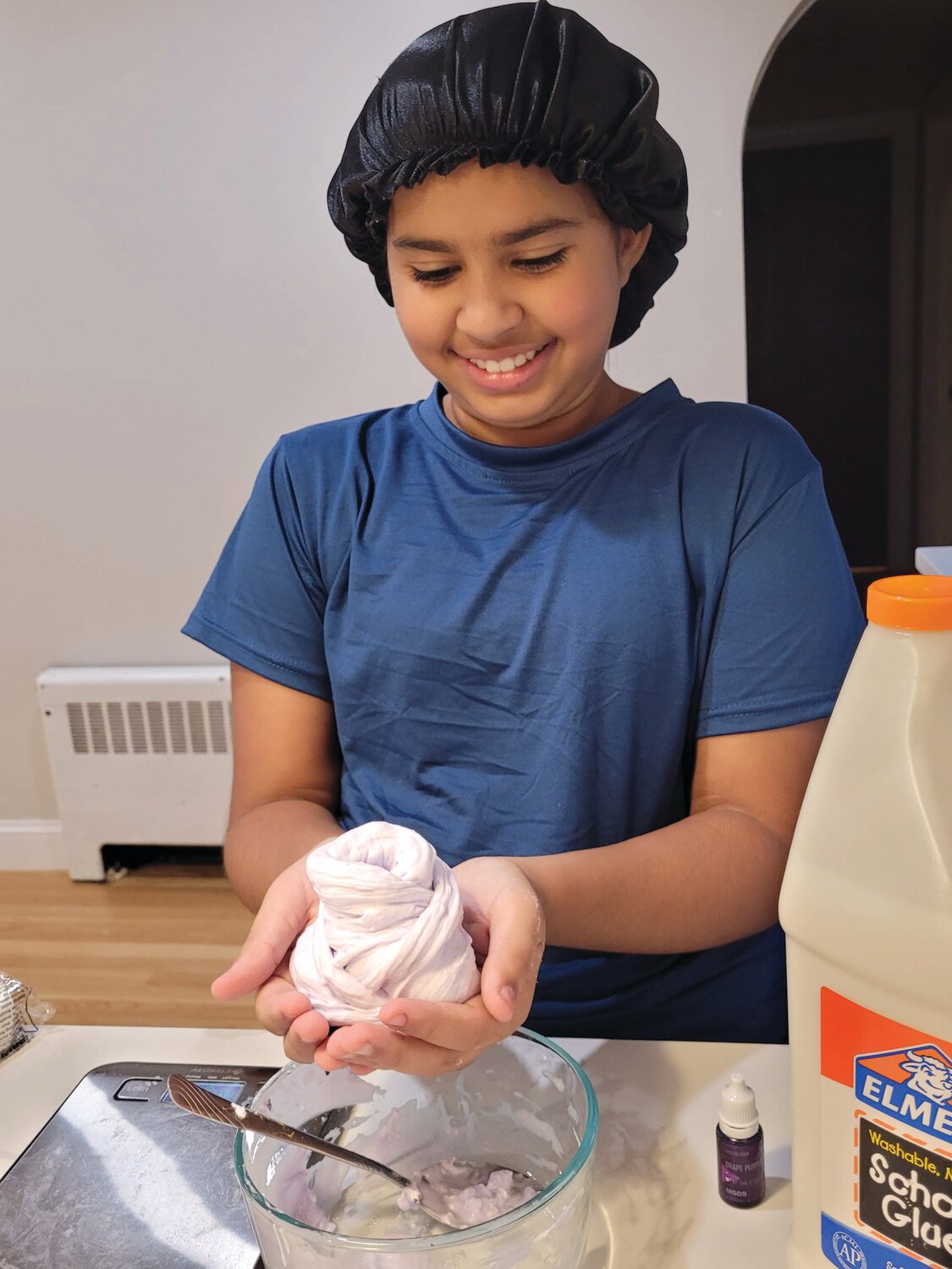 STRESS RELIEF: Santos needs to work the ingredients into the slime. Usually, she wears gloves while making slime for sale. Here, she demonstrates the technique on a sample batch of one of her favorite slimes, Lavender Butter Slime.